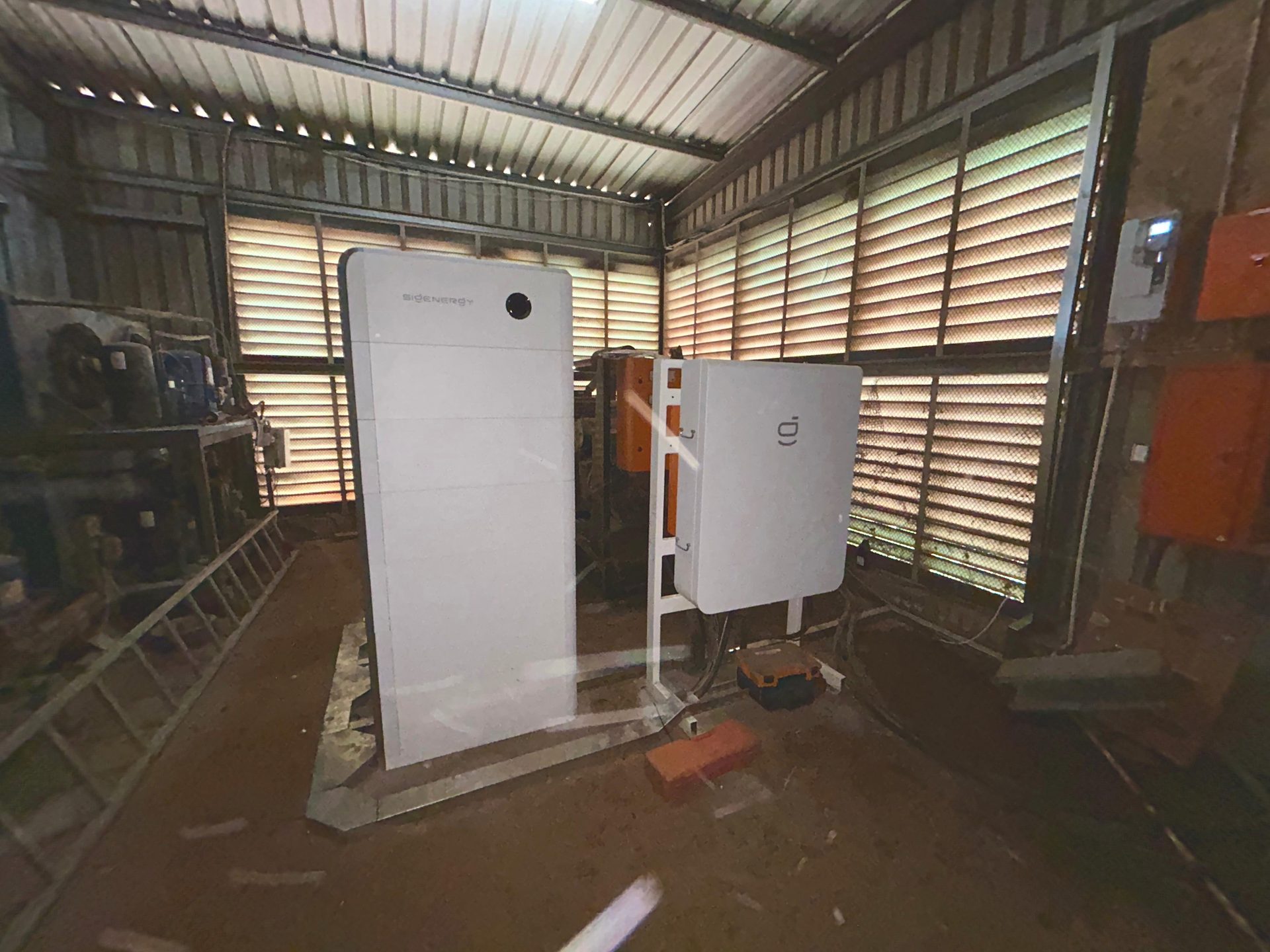 Wide view of a Sigenergy SigenStor battery stack and gateway cabinet installed in an agricultural shed at DB Dairy.