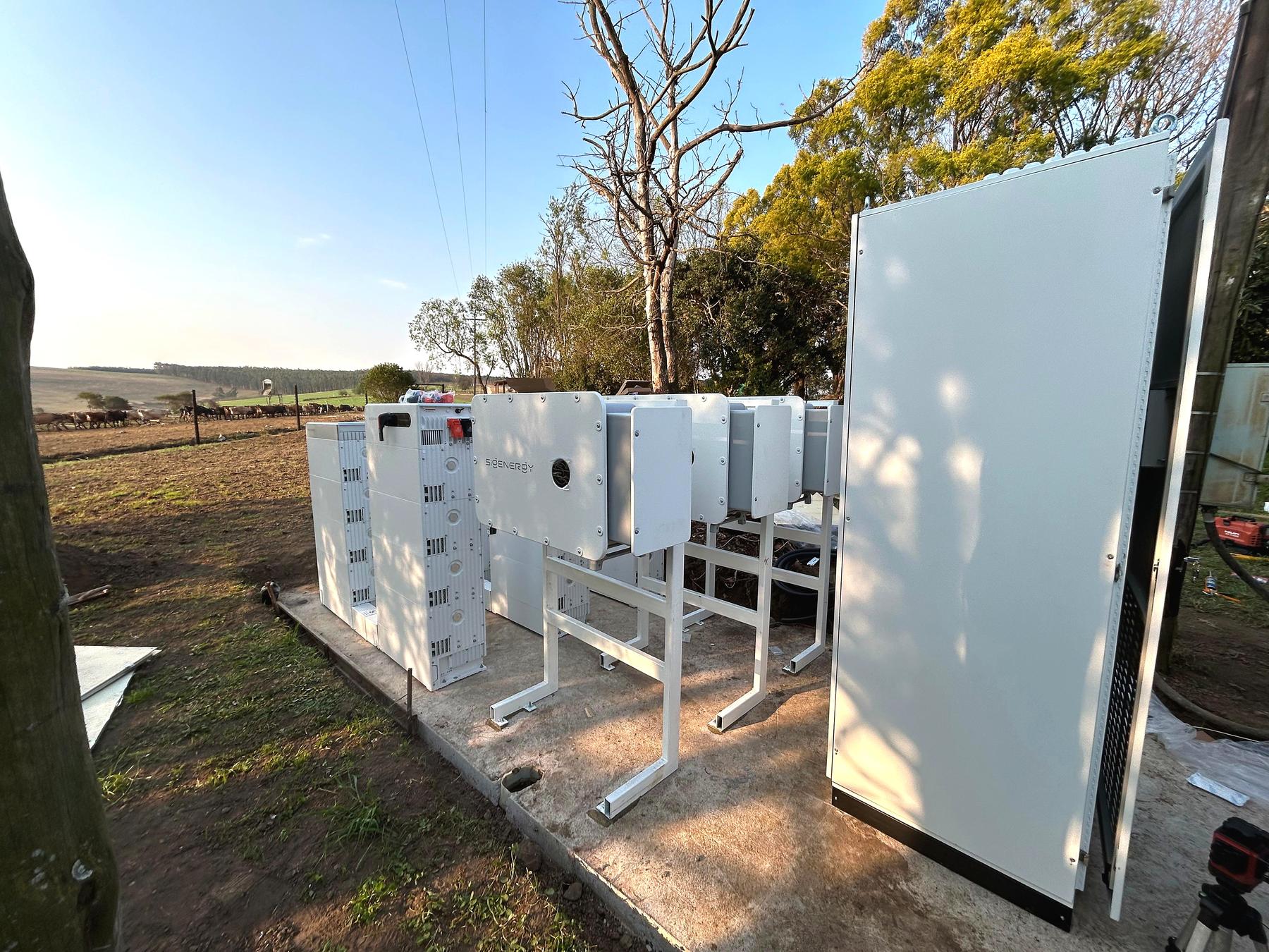 Sigenergy C&I and Sigen Stack equipment at GB Dairy with cattle grazing in the paddock behind the fence.